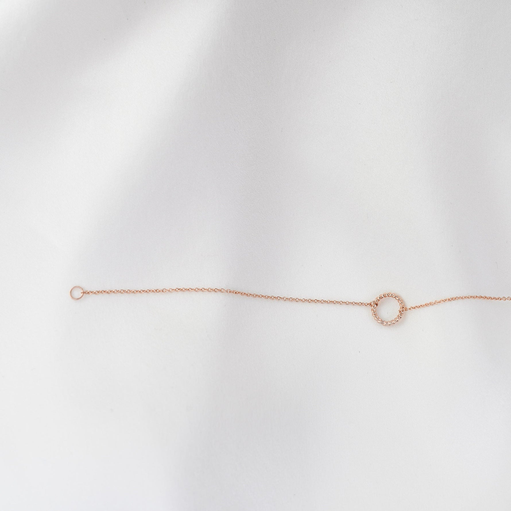 Rose gold bracelet on a light gray background