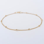 Gold anklet on a light gray background