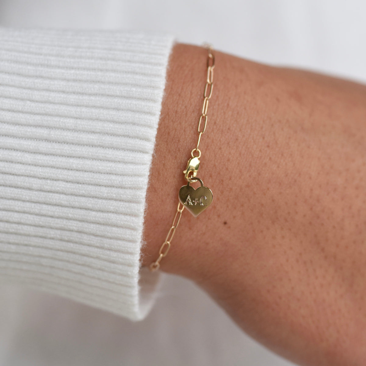14K gold personalized heart charm bracelet with paper clip chain, available in yellow and white gold, by Sash Jewelry.