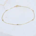 14K gold dainty chain bracelet with 1.5mm beads, thin and elegant jewelry by Sash Jewelry, shown close-up on a plain background.