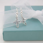 Silver earrings on a turquoise box with white ribbon