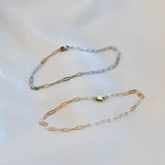 Two gold and silver chain necklaces on a light background