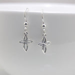 Silver cross-shaped earrings on a white background