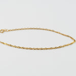 Close up of 14K solid yellow gold 1.8mm Singapore chain bracelet twisted detail
