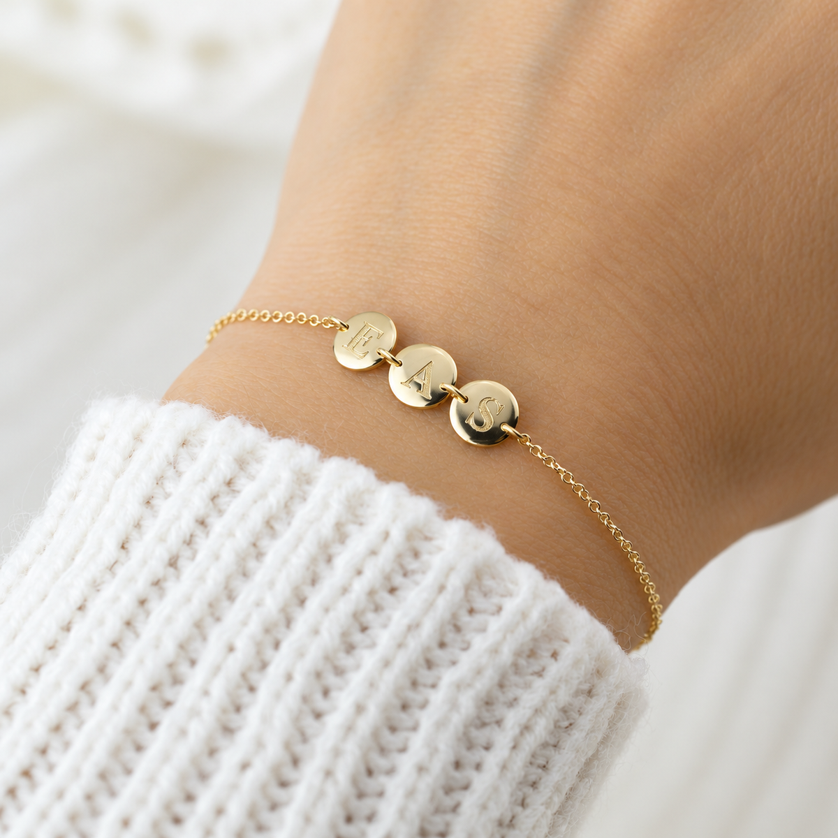 Personalized 14K solid gold initial disc bracelet from Sash Jewelry with small round gold discs on a delicate chain.